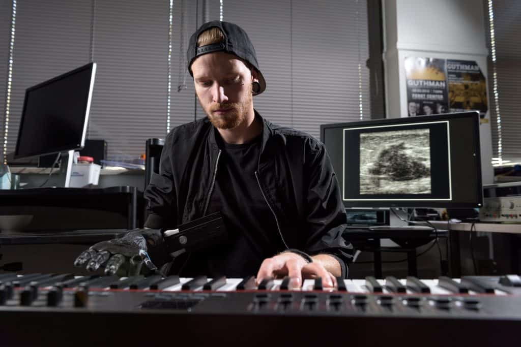 Jason Barnes at piano using his ultrasound prosthetic hand